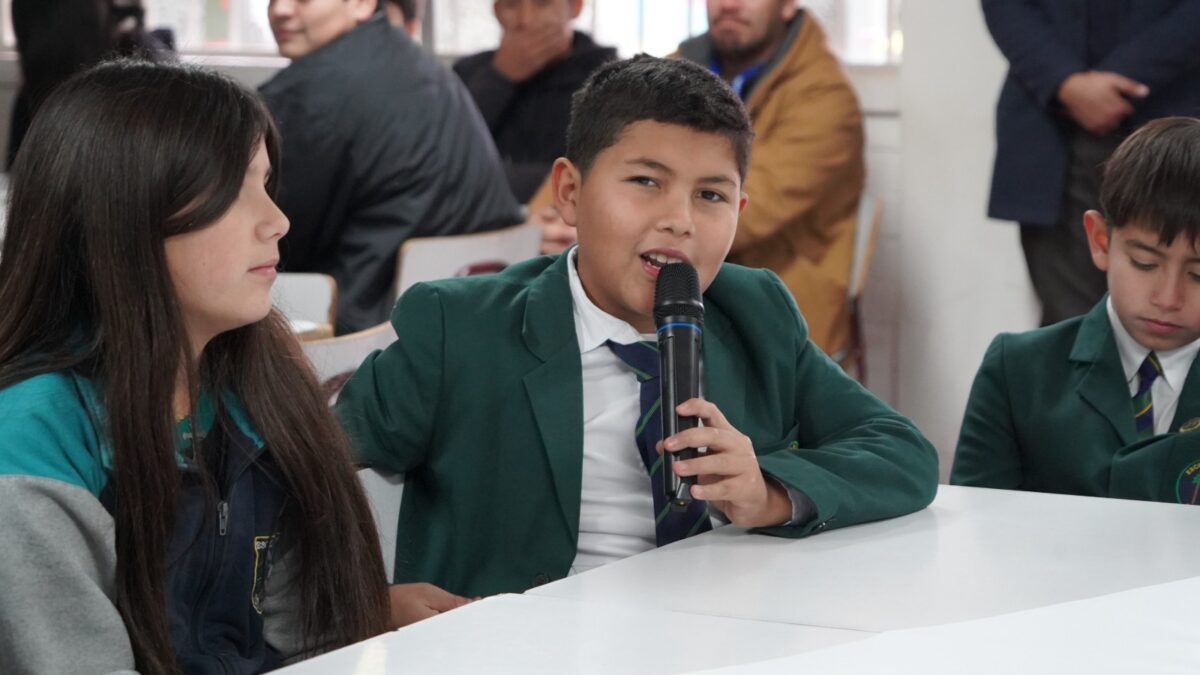 Un estudiante toma la palabra con un micrófono durante el plenario del encuentro.