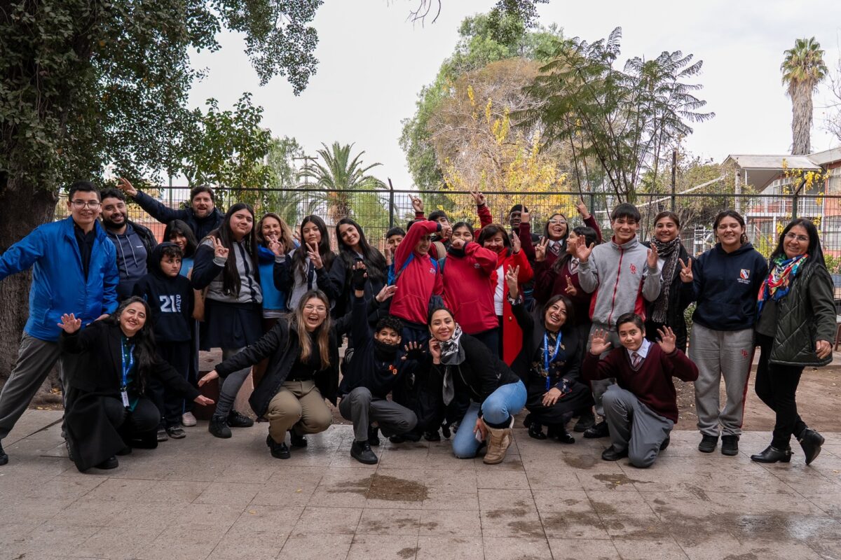 Estudiantes y profesionales participantes del encuentro de centros de estudiantes posan juntos en el patio del establecimiento.