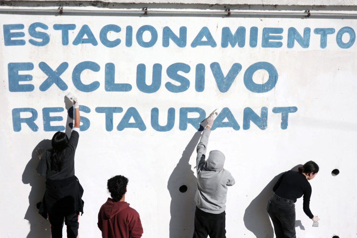 Pescadores y colaboradores pintando y preparando los muros de la caleta para la festividad.