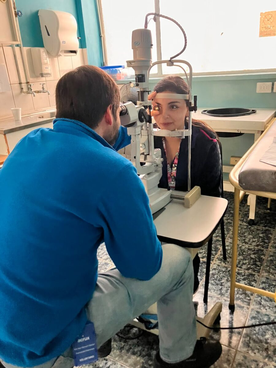Profesional voluntario realizando examen de oftalmología a una paciente durante el operativo.