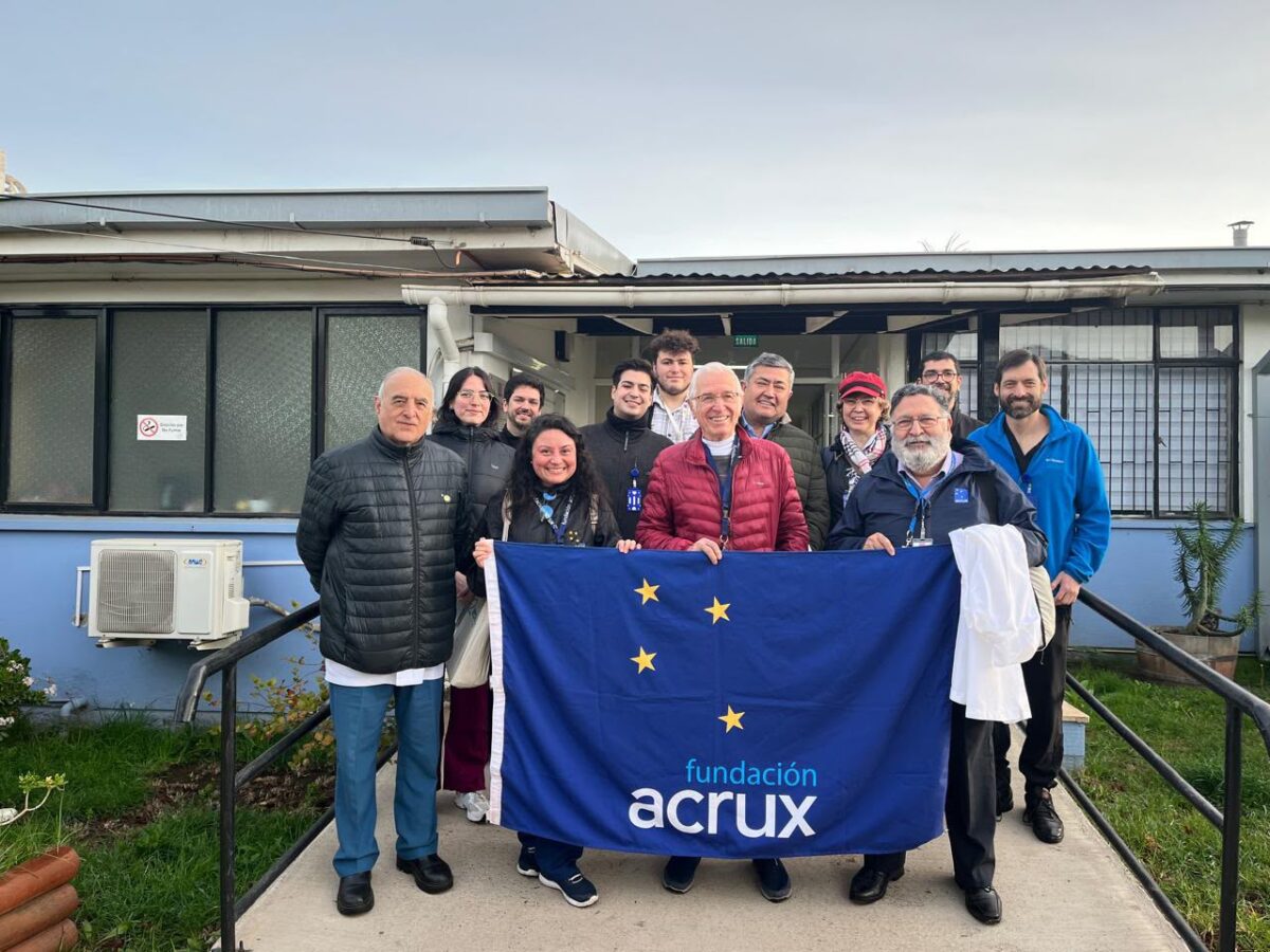Grupo de médicos voluntarios de la Fundación Acrux sosteniendo la bandera de la institución en el Hospital de La Ligua.