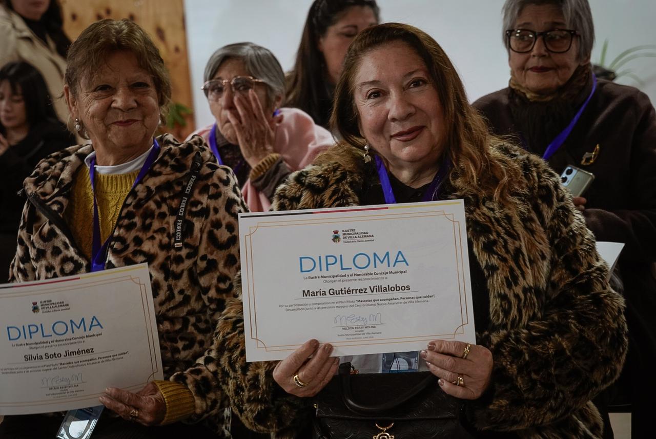Personas mayores mostrando orgullosas sus diplomas de monitores de tenencia responsable.