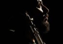 Retrato de perfil en penumbra del músico Gerardo Saks con su saxofón.
