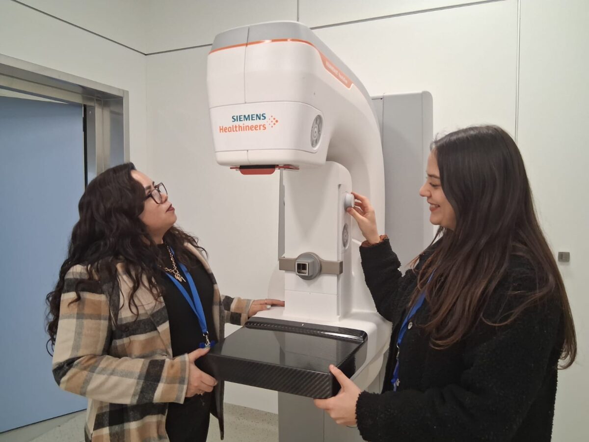 Profesionales de la salud revisando el moderno mamógrafo digital del recinto.