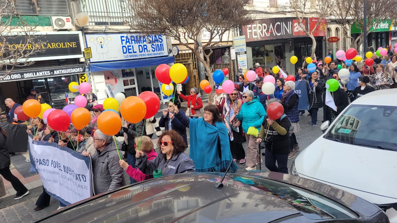 Asistentes a la caminata por el buen trato sosteniendo globos de colores en las calles de Viña del Mar.
