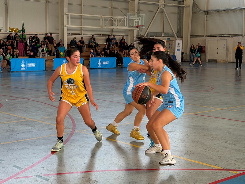 Acción de juego durante el campeonato de básquetbol de invierno en el Gimnasio Polideportivo Nicolás Massú.