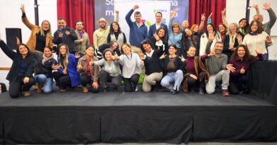 Grupo de agricultores sonriendo y posando en un escenario tras participar en un taller de branding.