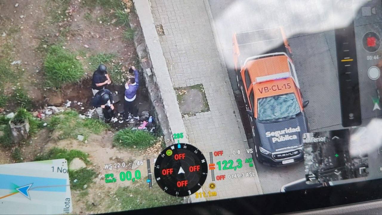 Vista aérea de un operativo de seguridad con personal de la PDI y un vehículo municipal.