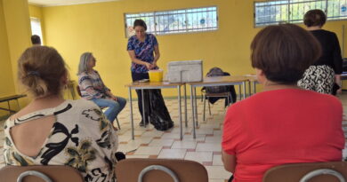 Una enfermera de SaludQuillota explicando el proceso de vacunación a un grupo de personas en una sala.