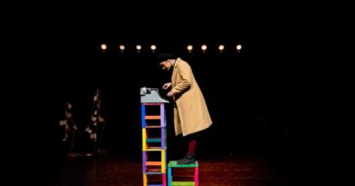 Intérprete sobre el escenario interactuando con una máquina de escribir en la obra Talar.