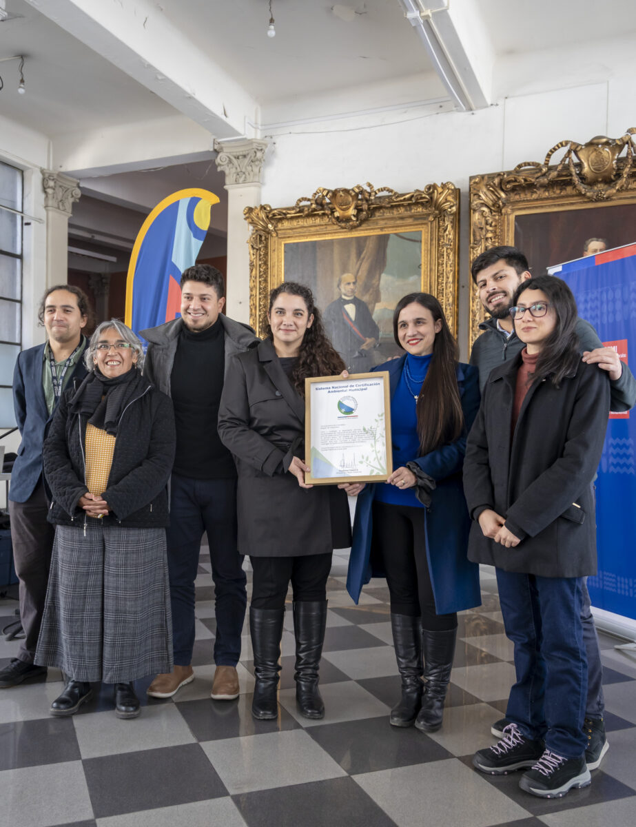 Autoridades municipales y representantes comunitarios sostienen el certificado de acreditación ambiental.