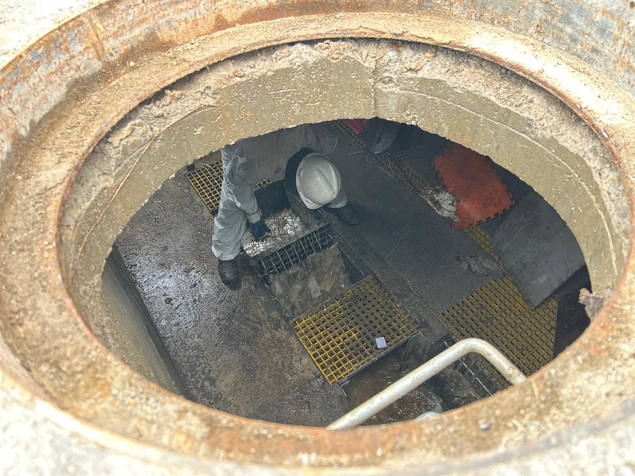 Operario de Esval inspeccionando el interior de una cámara de alcantarillado.