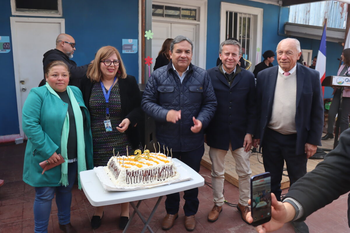 Alcalde Luis Mella junto a directivos y funcionarios celebrando los 23 años de la Casa de Acogida Beatita Benavides frente a una torta de aniversario.