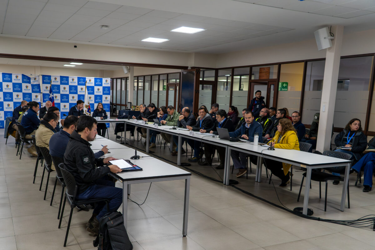 Autoridades y equipos de emergencia analizando mapas de riesgo geoespacial.