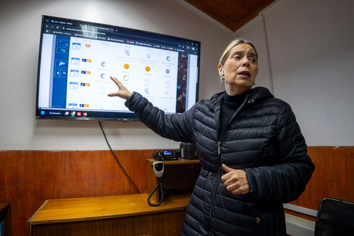 La alcaldesa de Quilpué, Carolina Corti, revisa los pronósticos meteorológicos en una pantalla.