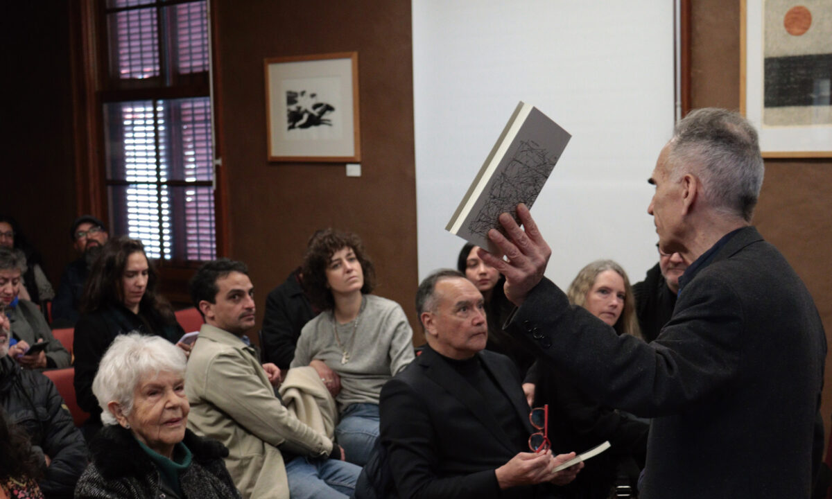 Ricardo Loebell mostrando el libro Palabra escondida ante la audiencia.