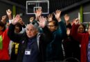 Personas mayores participando alegremente con las manos en alto en la Expo MÁS AMA 2026 de Quilpué.