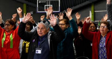 Personas mayores participando alegremente con las manos en alto en la Expo MÁS AMA 2026 de Quilpué.
