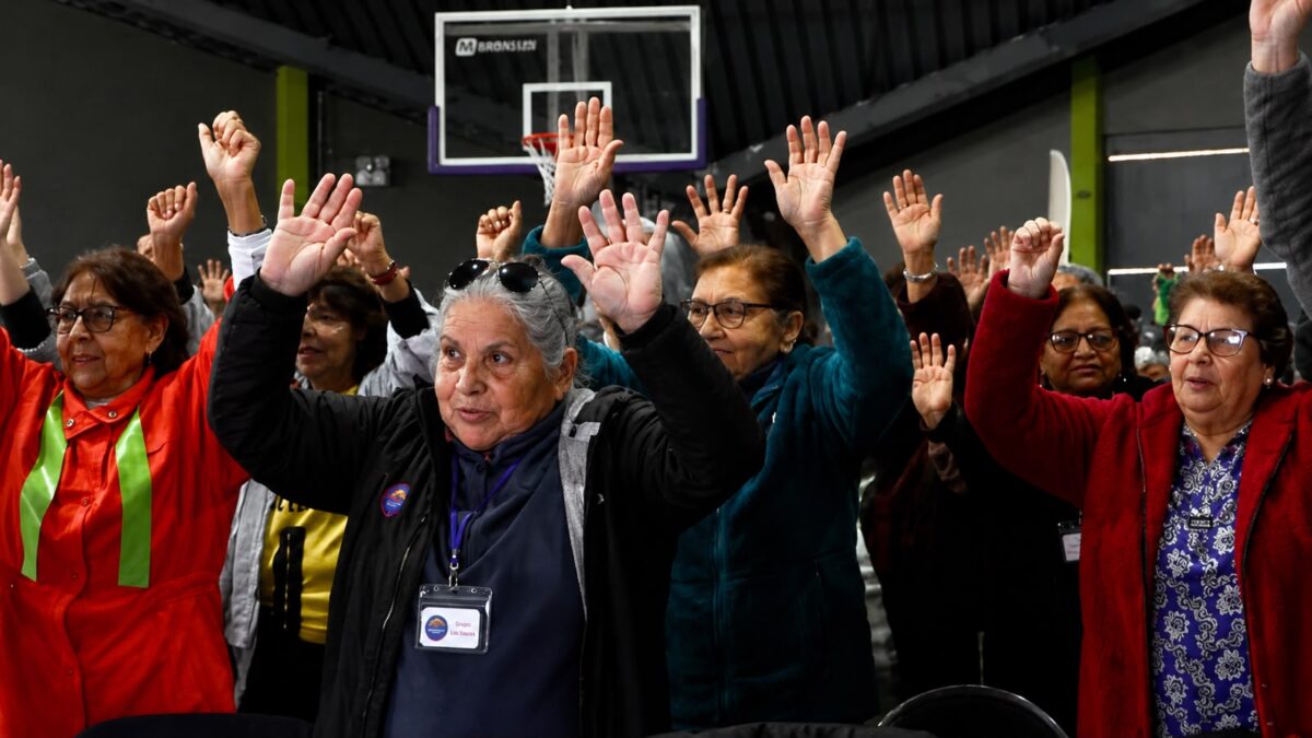 Personas mayores participando alegremente con las manos en alto en la Expo MÁS AMA 2026 de Quilpué.