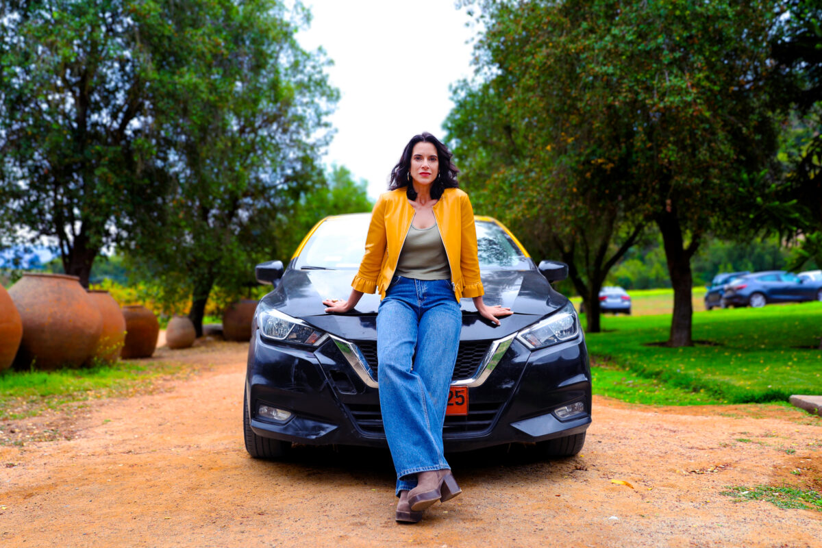 María José Illanes posando junto a un vehículo en el set de grabación.