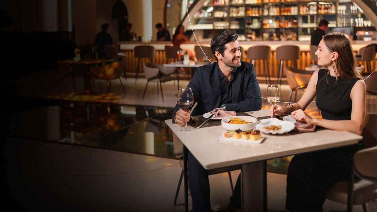 Pareja disfrutando de una experiencia gastronómica premium en un restaurante.