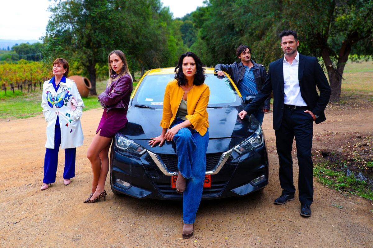 Elenco de la mininovela Mira de quién te burlaste junto a un vehículo de la producción.