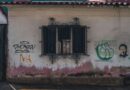 Fachada con rayados y grafitis en una pared urbana.