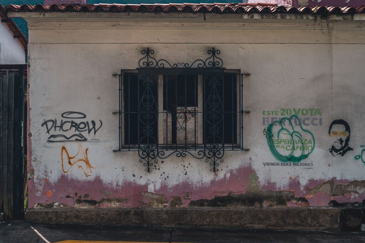 Fachada con rayados y grafitis en una pared urbana.
