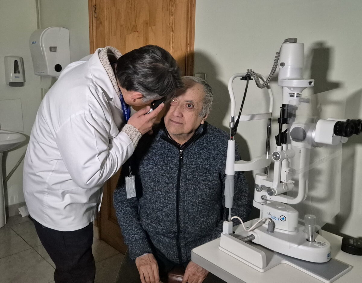 Médico oftalmólogo realizando revisión ocular a un paciente en el centro de salud.