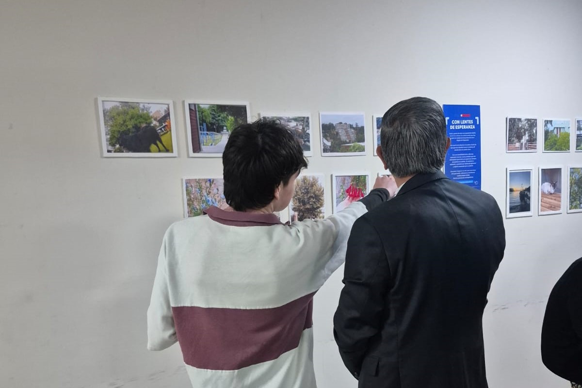 Asistentes observando la exposición fotográfica Con lentes de Esperanza en el Centro Cultural Daniel de la Vega.
