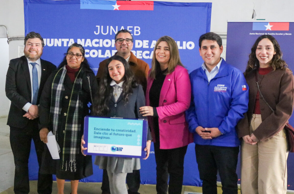 Estudiante junto a autoridades en la ceremonia de entrega de la Beca TIC.