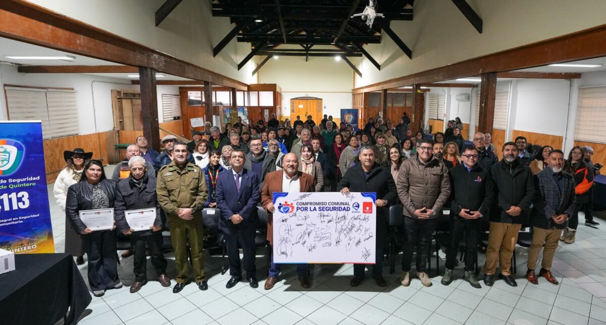 Autoridades y dirigentes vecinales posan con el documento del Compromiso Comunal por la Seguridad en Quintero.