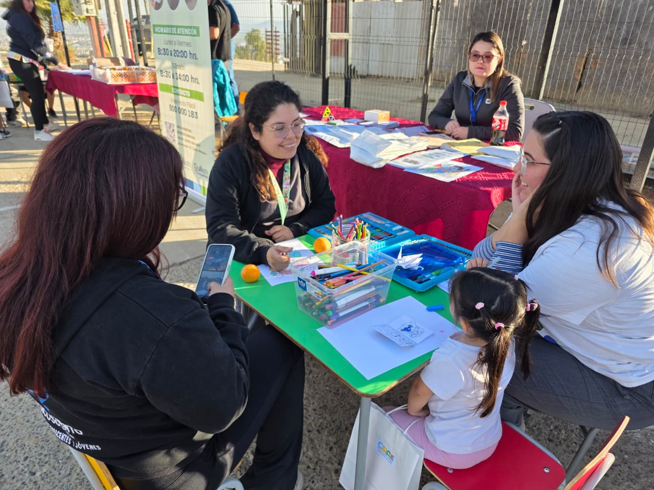Niños y adultos participando en talleres educativos y de dibujo en la jornada comunitaria.