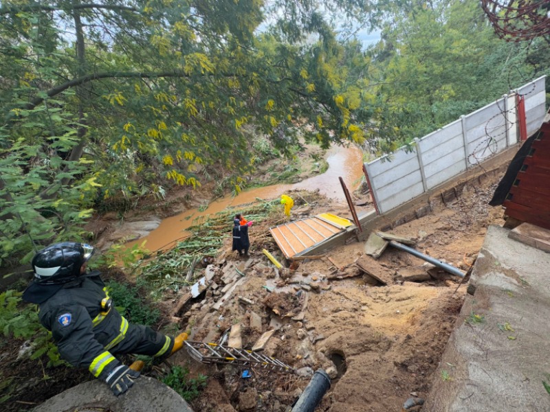 Personal de Bomberos evalúa el socavón en el borde del Estero Quilpué.