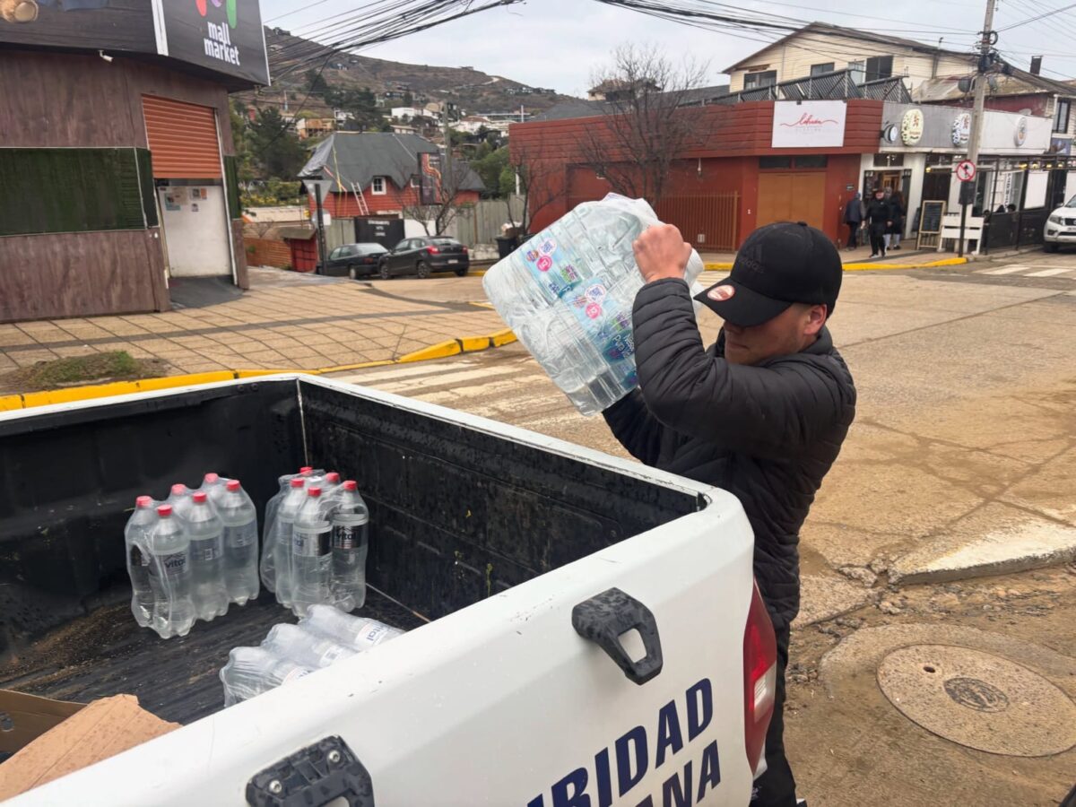 Funcionario municipal recolectando agua embotellada para la campaña solidaria en Papudo.