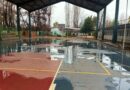 Cancha de establecimiento educacional con acumulación de agua tras el sistema frontal.