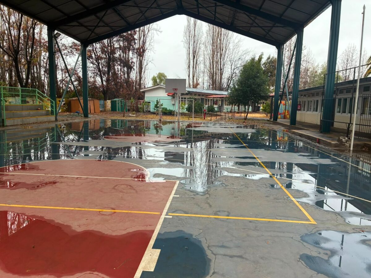 Cancha de establecimiento educacional con acumulación de agua tras el sistema frontal.