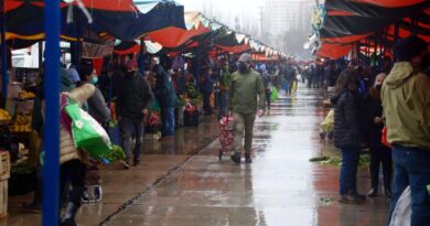 Comerciantes y clientes en una feria libre de Viña del Mar durante un día lluvioso.