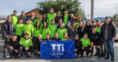 Voluntarios de la Universidad Adolfo Ibáñez posan con un lienzo conmemorativo de los 30 años de los Trabajos de Invierno en Quillota.