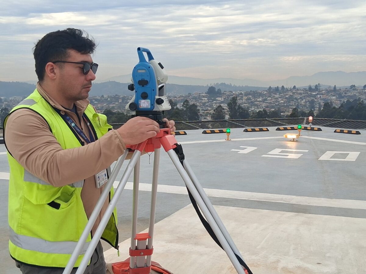 Especialista utilizando equipo topográfico durante la inspección técnica.