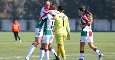 Jugadoras de fútbol celebrando un gol en el campo de juego.