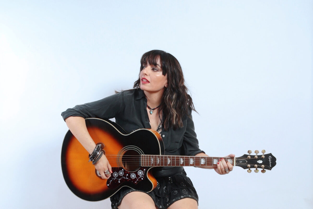 La cantautora Nacha Nava posando con su guitarra.