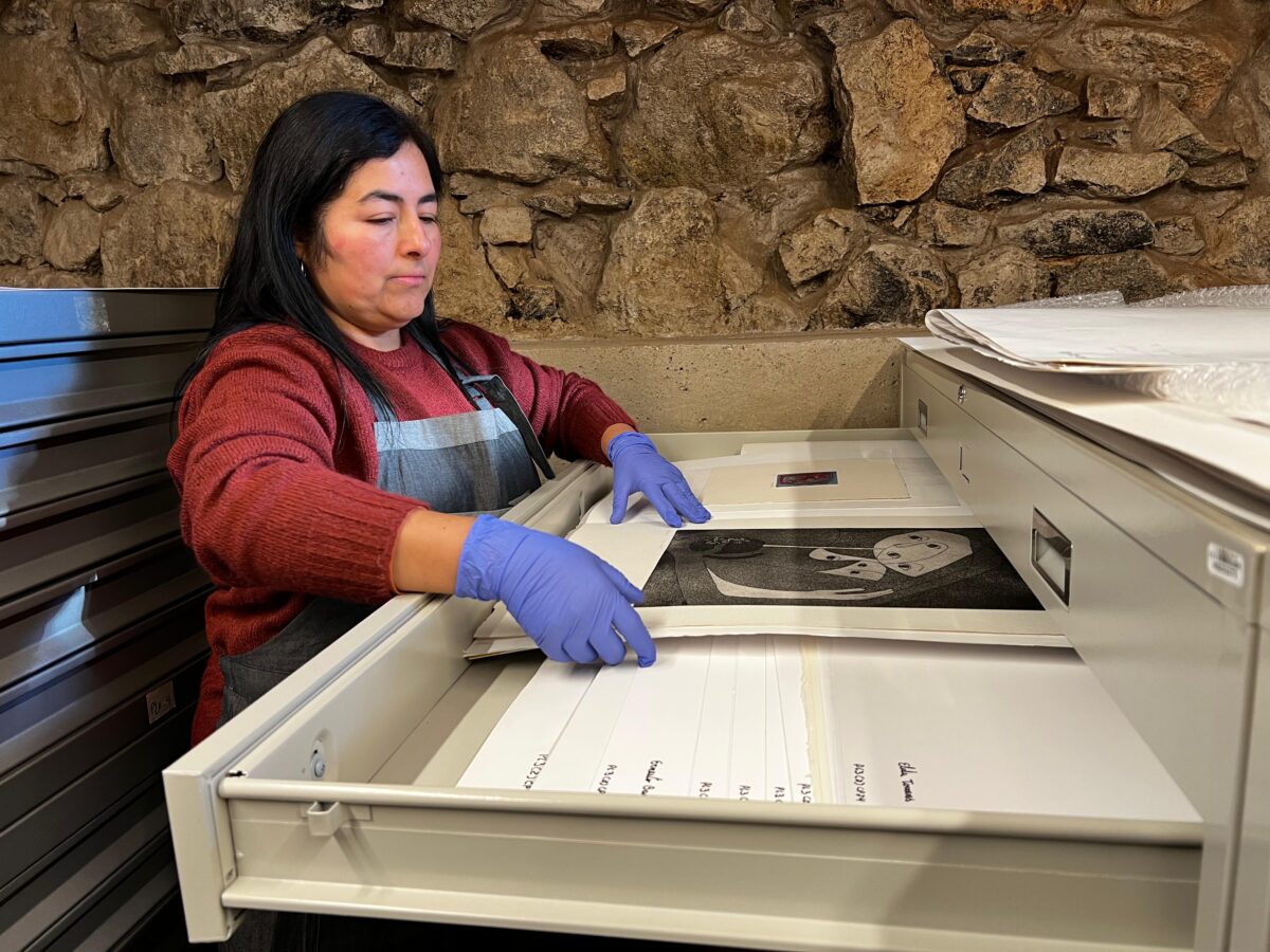 Viviana Zúñiga Rocha, encargada del Archivo de Artes Visuales, revisando obras del Fondo de las Artes de la UPLA.
