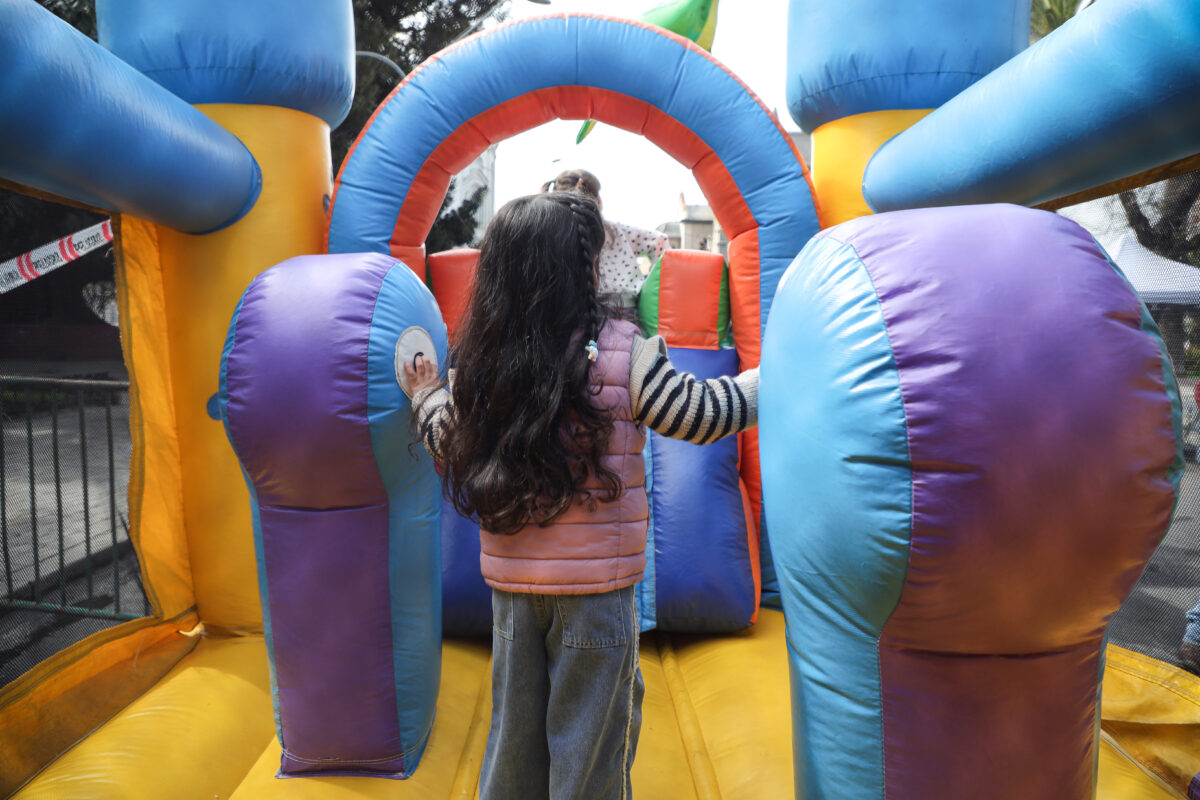 Niña jugando en un castillo inflable durante las actividades municipales.
