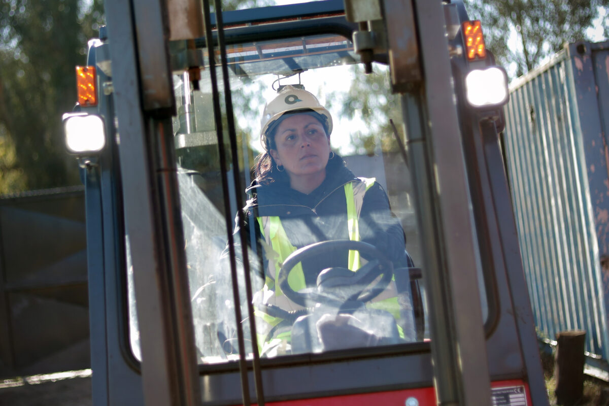 Detalle de participante operando los controles de la maquinaria.
