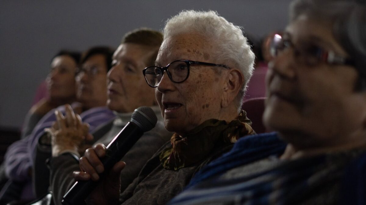 Asistente al festival compartiendo su opinión a través de un micrófono durante una jornada de cine.