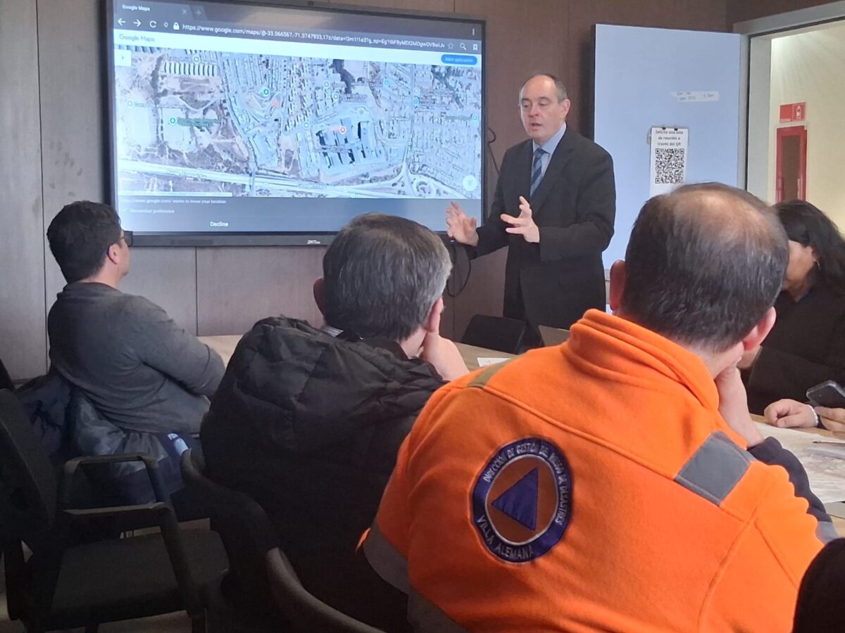 Autoridades y equipos de emergencia revisando mapas y logística en una reunión de coordinación.