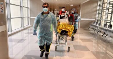 Personal de salud trasladando a un paciente simulado en camilla durante el ejercicio preparatorio.