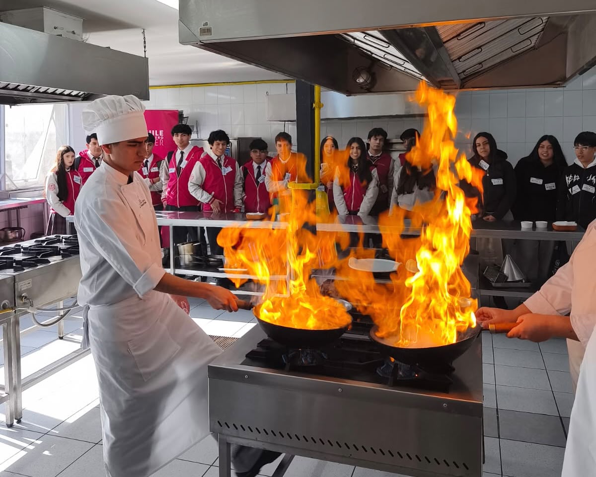 Estudiante de gastronomía realizando una demostración práctica con fuego en los talleres de la institución.