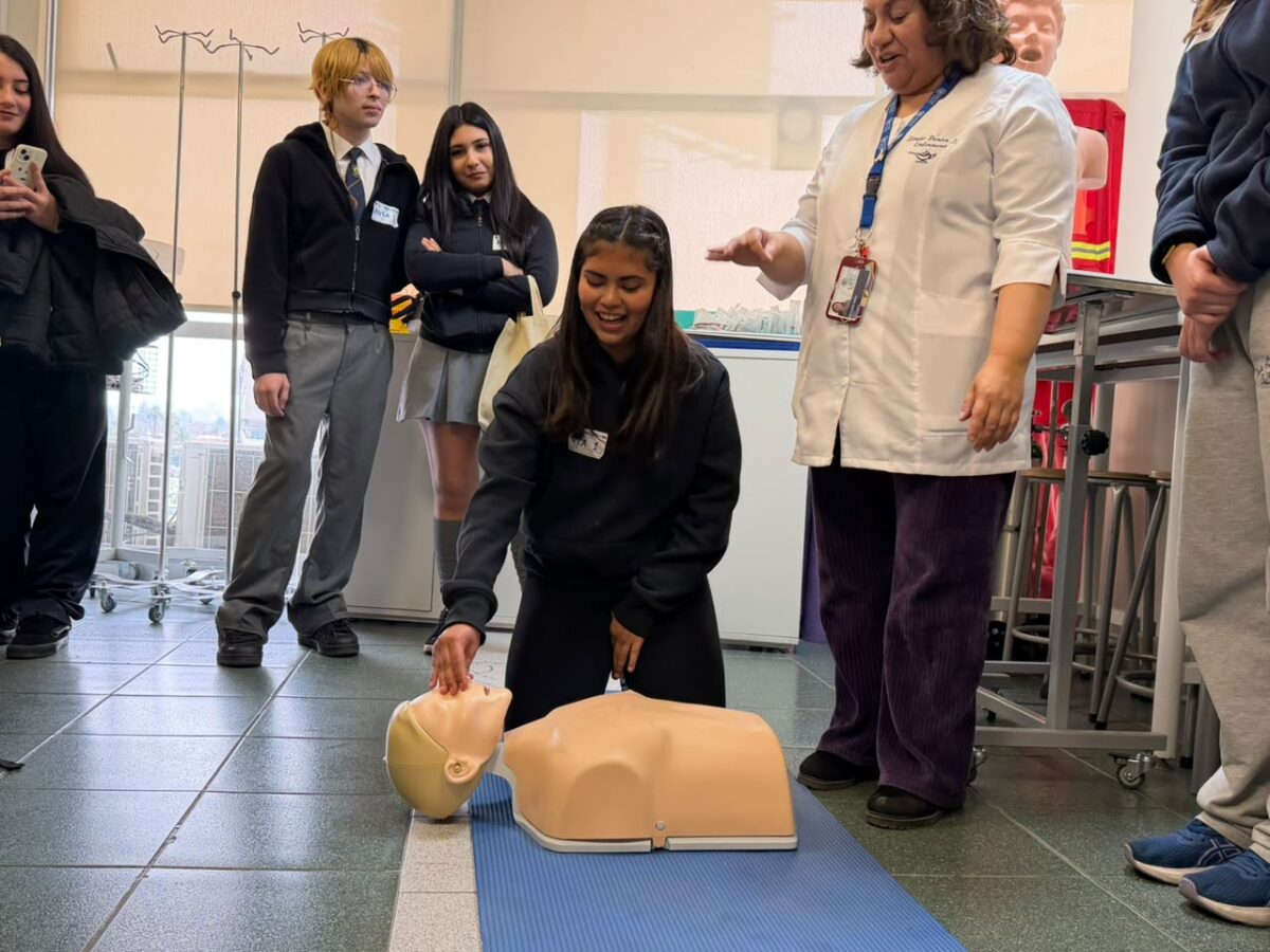 Estudiantes participando en una actividad práctica de primeros auxilios con maniquíes de simulación.